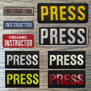 May include: Eight black patches with white, yellow and red lettering. The patches read "PRESS" and "FIREARMS INSTRUCTOR".