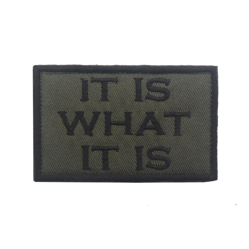 Peut inclure: Un patch brod&eacute; vert avec des coutures noires qui dit "IT IS WHAT IT IS".