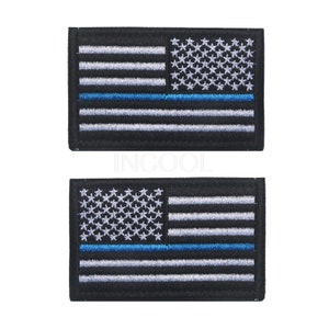 Pu&ograve; includere: Due toppe ricamate della bandiera americana con una sottile linea blu al centro. Le toppe sono nere con cuciture bianche e blu.