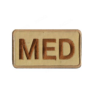 May include: A tan rectangular patch with brown embroidered letters that spell "MED".