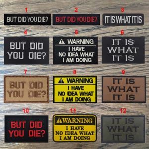 Może przedstawiać: Dwunastu haftowanych naszywek z różnymi powiedzeniami i wzorami. Naszywki są w różnych kolorach i stylach, w tym czarnym, brązowym, żółtym i zielonym. Naszywki zawierają tekst "But Did You Die?" i "It Is What It Is" w różnych czcionkach i kolorach. Niektóre naszywki zawierają również znak ostrzegawczy z tekstem "I Have No Idea What I Am Doing".