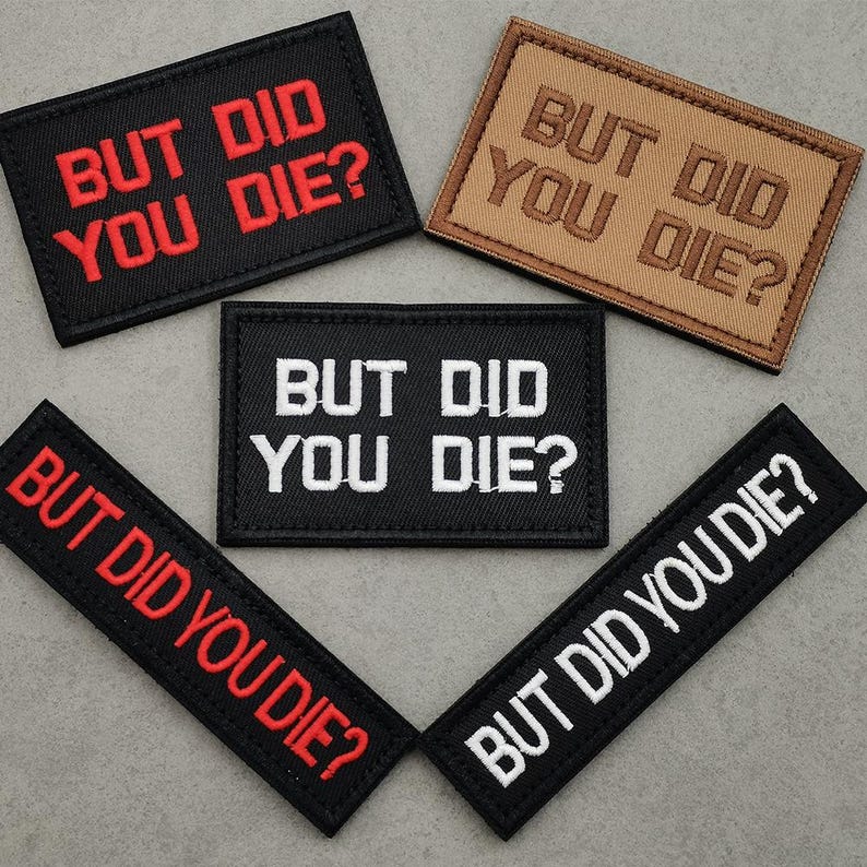 Peut inclure: Cinq patchs en tissu noir et marron avec des broderies blanches et rouges. Les patchs disent tous "But Did You Die?" dans diff&eacute;rents styles de police.