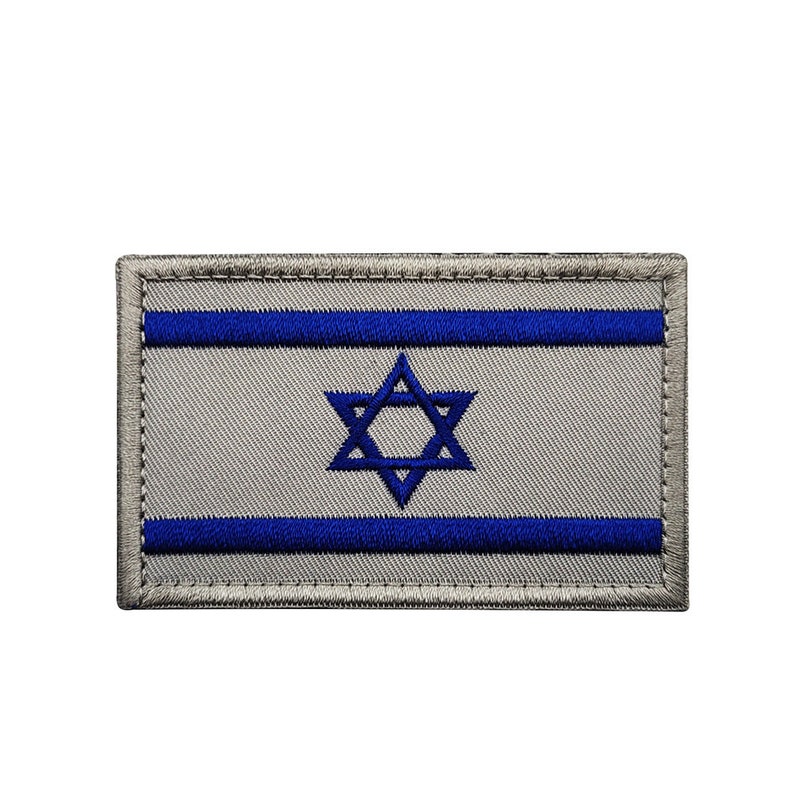 May include: A gray embroidered patch with the Israeli flag. The flag features two blue horizontal stripes and a blue Star of David in the center.