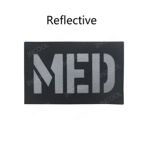 May include: A black rectangular patch with the word "MED" in reflective silver lettering. The patch is labeled "Reflective".