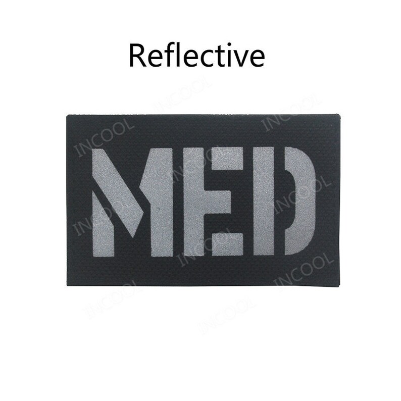 May include: A black rectangular patch with the word "MED" in reflective silver lettering. The patch is labeled "Reflective".