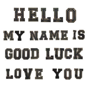 Puede incluir: Un conjunto de letras para planchar que deletrean "HELLO MY NAME IS GOOD LUCK LOVE YOU". Las letras son negras con un contorno blanco y tienen un acabado brillante y brillante.