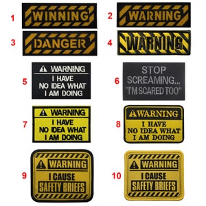 Puede incluir: Diez parches de advertencia amarillos y negros con varios mensajes humorísticos. Los parches son rectangulares y tienen un borde negro. Los mensajes incluyen "Winning", "Danger", "Warning I have no idea what I am doing", "Stop Screaming... "I'm Scared Too"", y "Warning I Cause Safety Briefs".