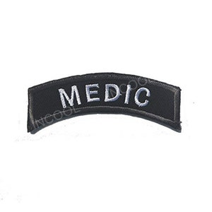 May include: Black curved patch with white embroidered text that reads "MEDIC".