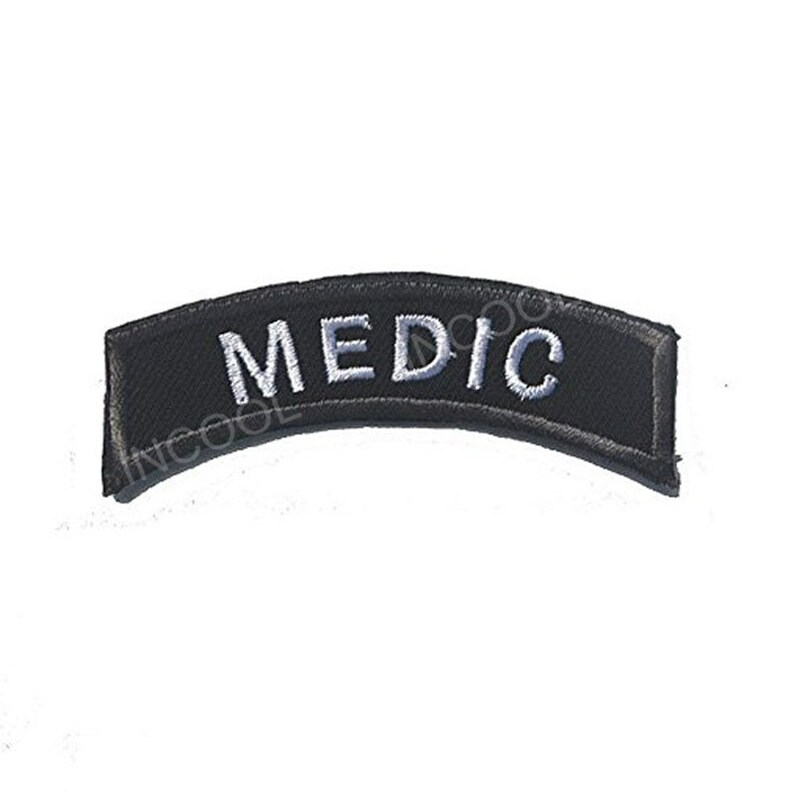 May include: Black curved patch with white embroidered text that reads "MEDIC".