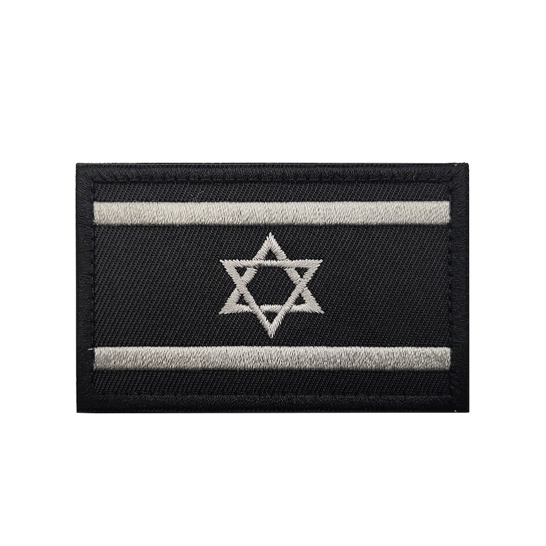 May include: A black embroidered patch with a white Star of David and two white stripes. The patch is a representation of the Israeli flag.
