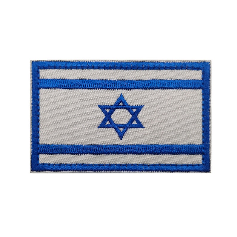 May include: A blue and white embroidered patch featuring the flag of Israel. The patch has a white background with two blue horizontal stripes and a blue Star of David in the center.