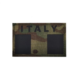 May include: A camouflage fabric patch with the word "ITALY" printed in black letters. The patch has two black rectangular areas.