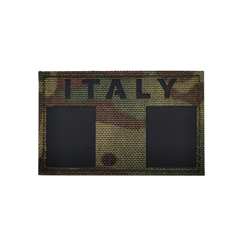 May include: A camouflage fabric patch with the word "ITALY" printed in black letters. The patch has two black rectangular areas.