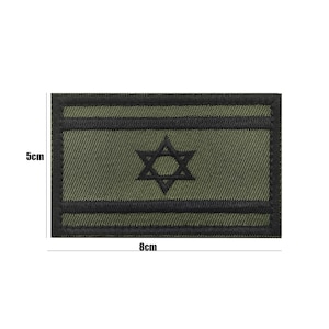 May include: A green and black embroidered patch with a six-pointed star in the center. The patch measures 8 cm by 5 cm.