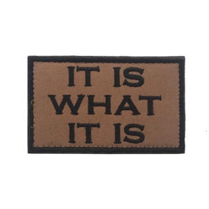 Peut inclure: Un patch marron avec du texte brod&eacute; noir qui dit "IT IS WHAT IT IS".