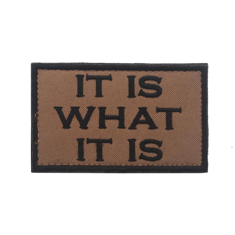 Peut inclure: Un patch marron avec du texte brod&eacute; noir qui dit "IT IS WHAT IT IS".