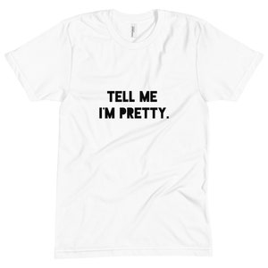 May include: White t-shirt with black text that reads "TELL ME I'M PRETTY."