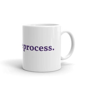 May include: White ceramic coffee mug with a purple inscription that reads "the process."