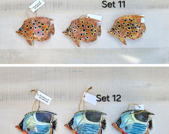 May include: Two sets of three colorful fish ornaments. The first set features three orange fish with black spots. The second set features three blue fish with black and white stripes. Each set is labeled with a number, "Set 11" and "Set 12".