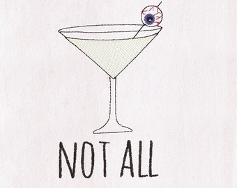 May include: Embroidered design on white fabric featuring a martini glass with an eyeball garnish. The text "NOT ALL Halloween" is below the glass. The martini is light green, the eyeball is red and purple, and the text is black and green.