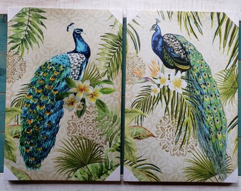 May include: Two framed prints of peacocks with intricate tail feathers, set against a background of lush green foliage and delicate white flowers. The prints feature a vintage-inspired design with a cream-colored background and ornate patterns.