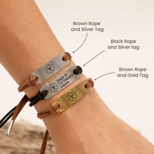 Puede incluir: Tres pulseras de alerta m&eacute;dica con cuerdas y etiquetas de diferentes colores. Las pulseras tienen una etiqueta plateada con el texto "Angie B T2 Diabetic Insulin" y un s&iacute;mbolo m&eacute;dico, una cuerda negra y una etiqueta plateada, y una cuerda marr&oacute;n y una etiqueta dorada.