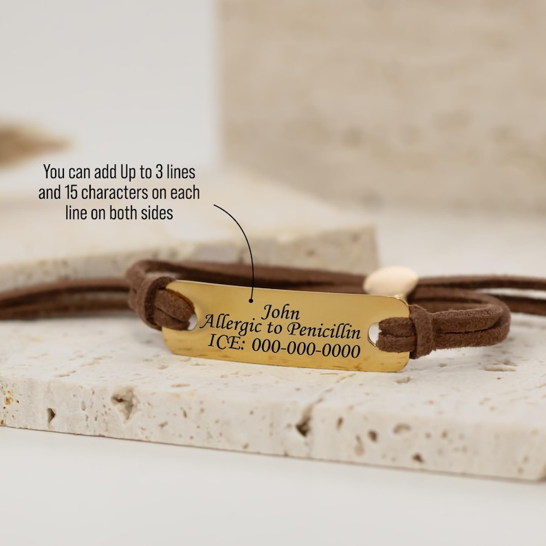 Puede incluir: Un brazalete de cuero marr&oacute;n con una etiqueta de metal dorado grabada con el texto "John Al&eacute;rgico a la Penicilina ICE: 000-000-0000".