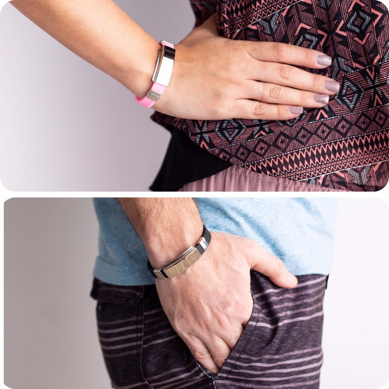 K&ouml;nnte beinhalten: Zwei Personen tragen silberne Armb&auml;nder mit schwarzen und rosa B&auml;ndern. Die Armb&auml;nder haben eine rechteckige Metallplatte.