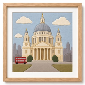 May include: A framed fabric wall art piece depicting St. Paul's Cathedral in London. The scene features a beige cathedral with a grey dome, a red double-decker bus, white clouds, and a light blue sky, all rendered in layered textile applique.