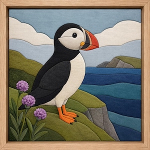 Puede incluir: Una pieza de arte mural de tela enmarcada que muestra un frailecillo con plumas negras y blancas, pico naranja y patas naranjas. El ave está sobre un acantilado verde con flores moradas, con vistas a un océano azul y un cielo nublado.