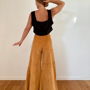Pantalón acampanado de pana color mostaza, de pierna ancha y talle alto, corte años 70.