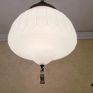 May include: A white frosted glass pendant light fixture with a decorative chain and a brown metal finial.