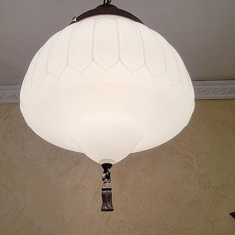 May include: A white frosted glass pendant light fixture with a decorative chain and a brown metal finial.