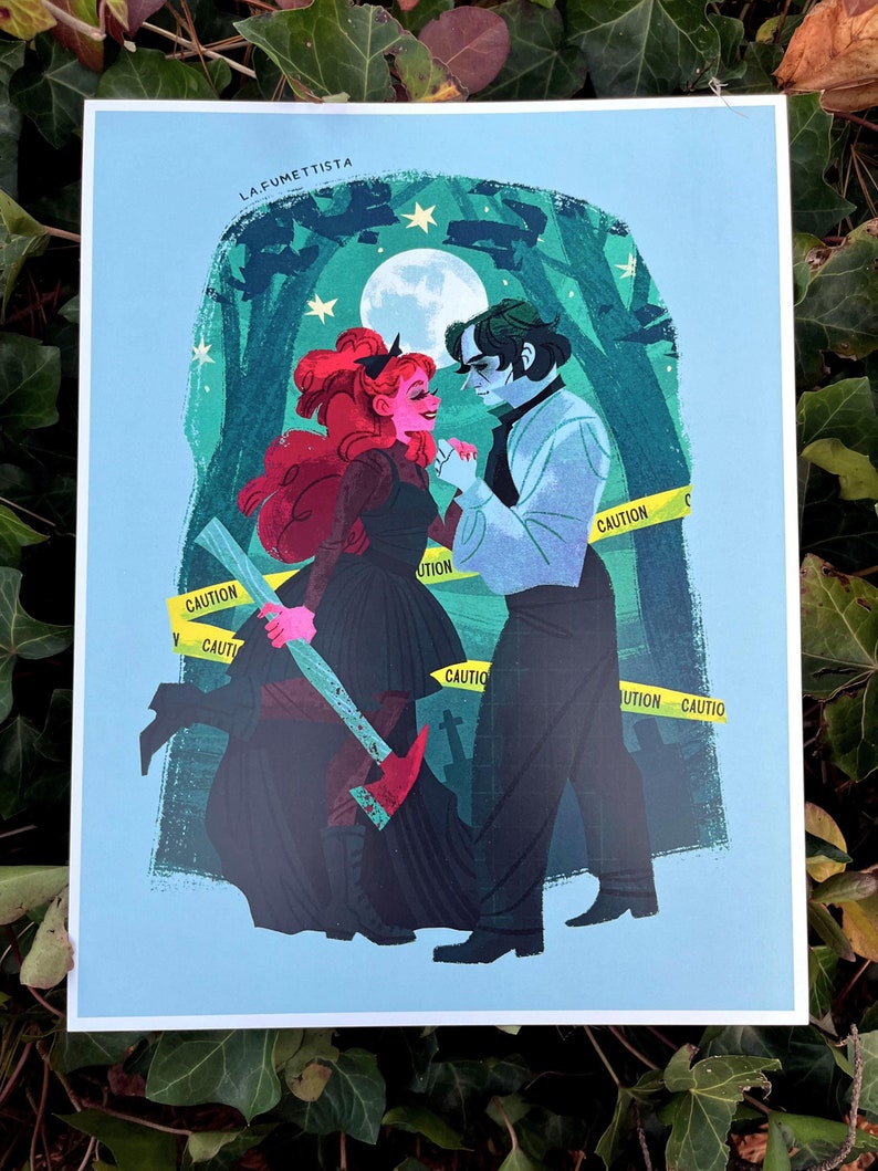 May include: A print of a couple standing in a forest at night. The woman is wearing a black dress and holding a bloody axe. The man is wearing a white shirt and black pants. The background is a dark green forest with a full moon in the sky. The text "LA FUMETTISTA" is at the top of the print. There is yellow caution tape around the couple.