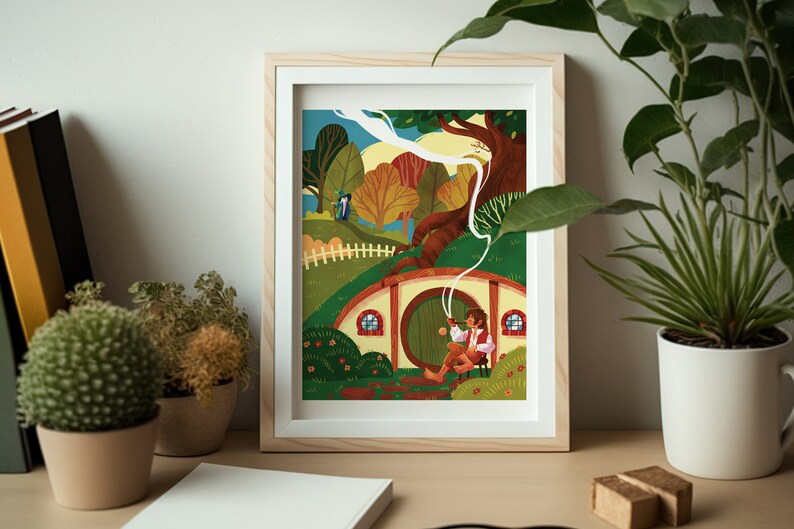 Op de afbeelding: Een ingelijste illustratie van een hobbit die buiten een ronde, groene deur zit met rook uit een pijp. De hobbit draagt een bruin shirt en broek en een rode sjaal. De deur bevindt zich aan een klein, rond huis met een bruin dak en twee ramen. Het huis is omgeven door groen gras en bomen. De illustratie is geplaatst tegen een blauwe lucht met witte wolken.