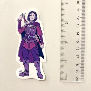 Puede incluir: Una ilustraci&oacute;n morada y roja de una mujer con una t&uacute;nica de manga larga, pantalones y botas. Ella sostiene una espada en su mano derecha y tiene una expresi&oacute;n decidida en su rostro. La ilustraci&oacute;n est&aacute; sobre un fondo blanco.