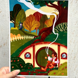 Op de afbeelding: Een kleurrijke illustratie van een hobbit die op een stoel zit voor een ronde deur, terwijl hij een pijp rookt. De hobbit draagt een bruin shirt en broek en heeft bruin haar. De deur is groen en heeft een rond raam. De achtergrond is een groene heuvel met een wit hek en bomen.