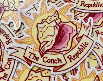 May include: A sticker featuring a conch shell with a sunburst design and the text "The Conch Republic". The sticker is white with red, yellow, and orange accents.