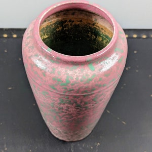Może przedstawiać: R&oacute;żowy ceramiczny wazon z zielonymi plamkami. Wazon ma okrągły otw&oacute;r i cylindryczny kształt.