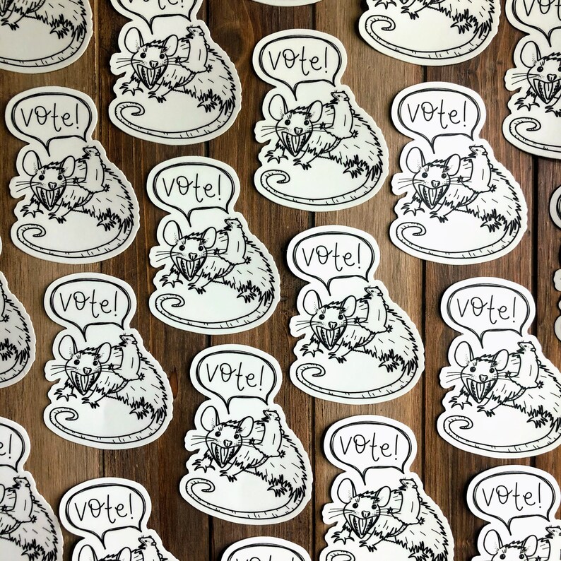 May include: A set of 12 black and white stickers featuring a cartoon rat holding a sign that says "Vote!" The rat is wearing a hat and has a big smile. The stickers are perfect for adding a touch of humor to your laptop, water bottle, or notebook.