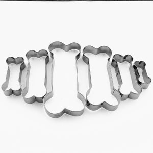 May include: Set of six stainless steel dog bone cookie cutters of varying sizes.