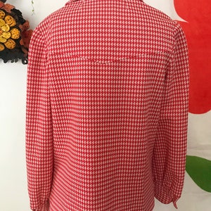 May include: A red and white gingham button-up shirt with long sleeves and a collared neckline.