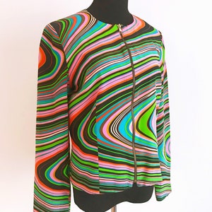 May include: A black and white striped jacket with pink, green, blue, and orange wavy lines. The jacket has a zipper closure.