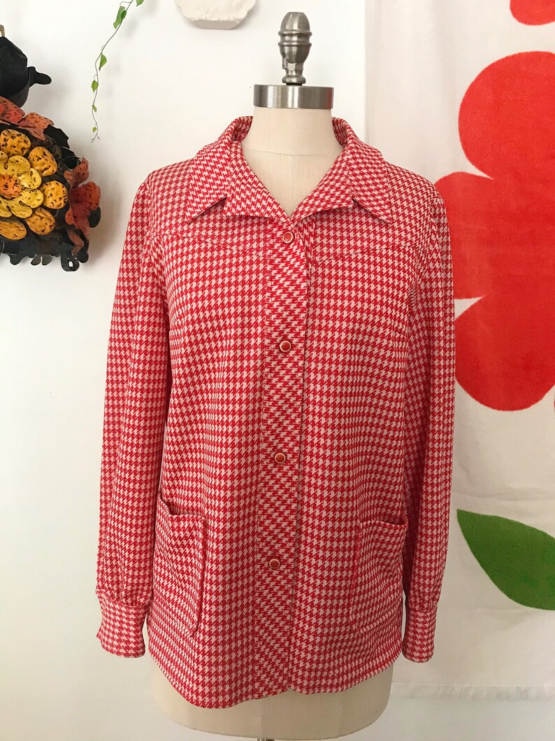 May include: A red and white gingham button-up shirt with long sleeves and two patch pockets. The shirt is on a white mannequin.