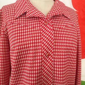 May include: A red and white houndstooth patterned jacket with a button-up front.
