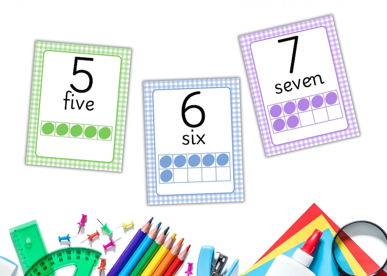 May include: Educational flashcards with numbers 5, 6, and 7, each with the number, word, and a ten-frame representation. The cards have a gingham border in green, blue, and purple. School supplies like pencils, a ruler, and glue are in the foreground.