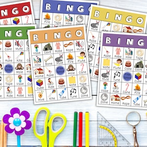 May include: Five colorful bingo cards with different images, including a rope, a cake, a mute button, a bone, a fire, a rake, a kite, a hike, a flute, a tape, a vase, a cube, a mule, a hive, a ride, a robe, a note, a dime, a home, a tube, a cane, a fire, a kite, a cave, a mole, a rake, a tune, a free space, a note, a tape, a cube, a mute button, a vase, a ride, a cane, a fire, a kite, a dime, a home, a rope, a tube, and a bone.