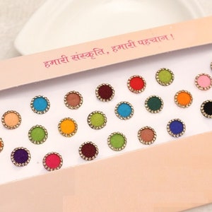 May include: A pack of 20 colorful 8 mm round bindi stickers. The bindi stickers are arranged in a grid pattern on a white card with a pink background. The card has the text "हमारी संस्कृति. हमारी पहचान!" in Hindi.