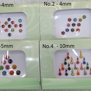 Puede incluir: Cuatro contenedores de plástico transparente con fondo blanco, cada uno contiene una variedad de pegatinas de piedras preciosas de colores. Los contenedores están etiquetados con los números del 1 al 4 y el tamaño de las pegatinas en milímetros. Las pegatinas están dispuestas en diferentes patrones, incluyendo un triángulo, un círculo y una línea.