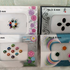 Puede incluir: Cuatro tarjetas blancas con bordes y diseños coloridos. Cada tarjeta presenta un conjunto diferente de piedras de imitación de colores, con tamaños que van de 5 mm a 9 mm. Las tarjetas están etiquetadas con números y tamaños, como "No. 1 - 5 mm" y "No. 4 - 9 mm".